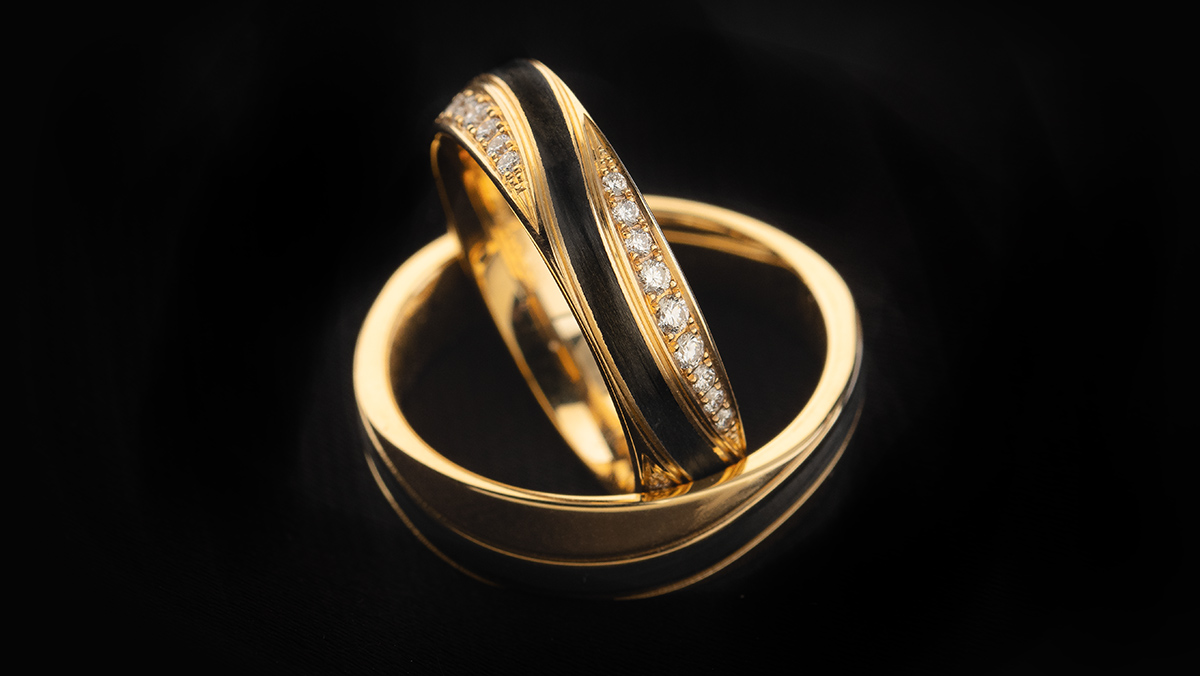 Paar Eheringe in Bicolor, Gold mit schwarzer Linie und Diamanten an den Seiten
