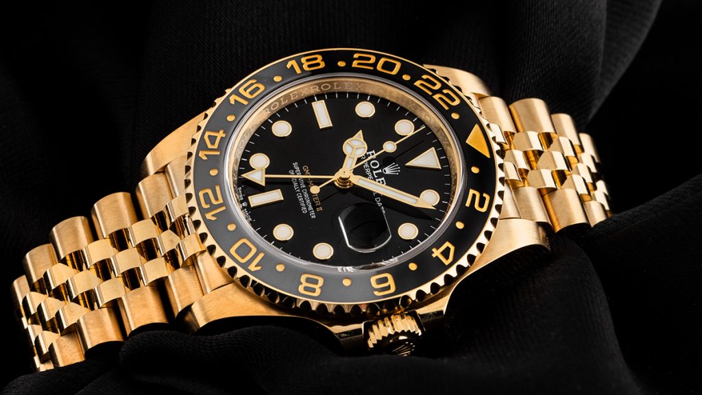Goldene Rolex mit schwarzem Zifferblatt und Lünette
