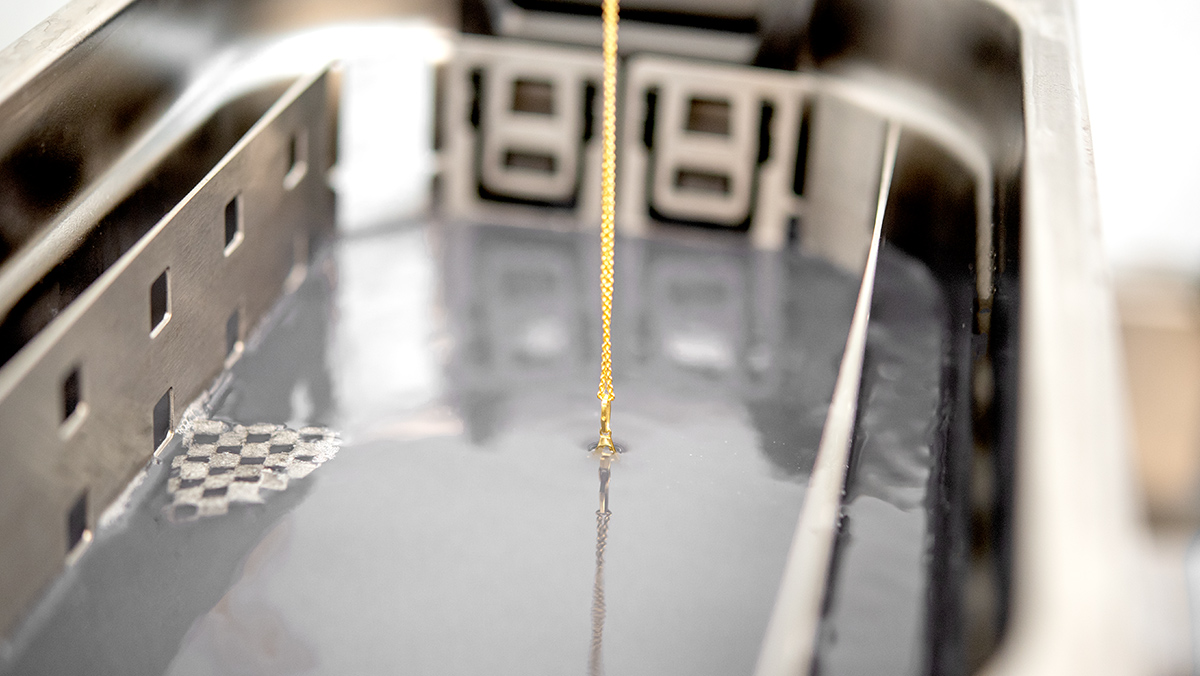 Goldene Halskette wird in ein Ultraschallgerät gelegt