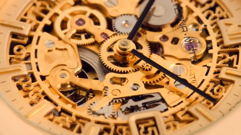 Goldenes Zifferblatt in Nahaufnahme mit kunstvoller Skelettierung