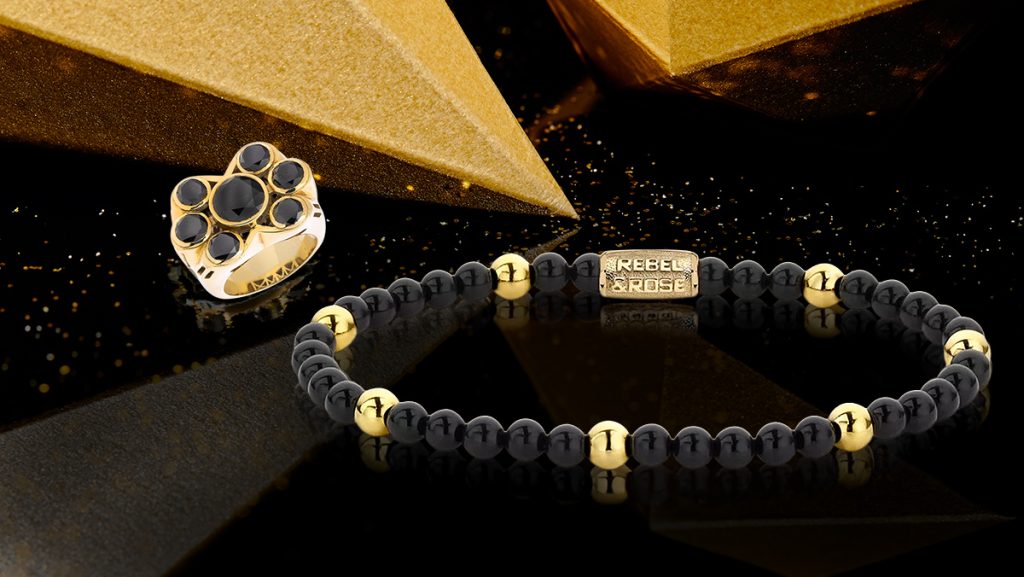 Auswahl aus Herrenschmuck: schwarz-goldenes Armband und passender Ring