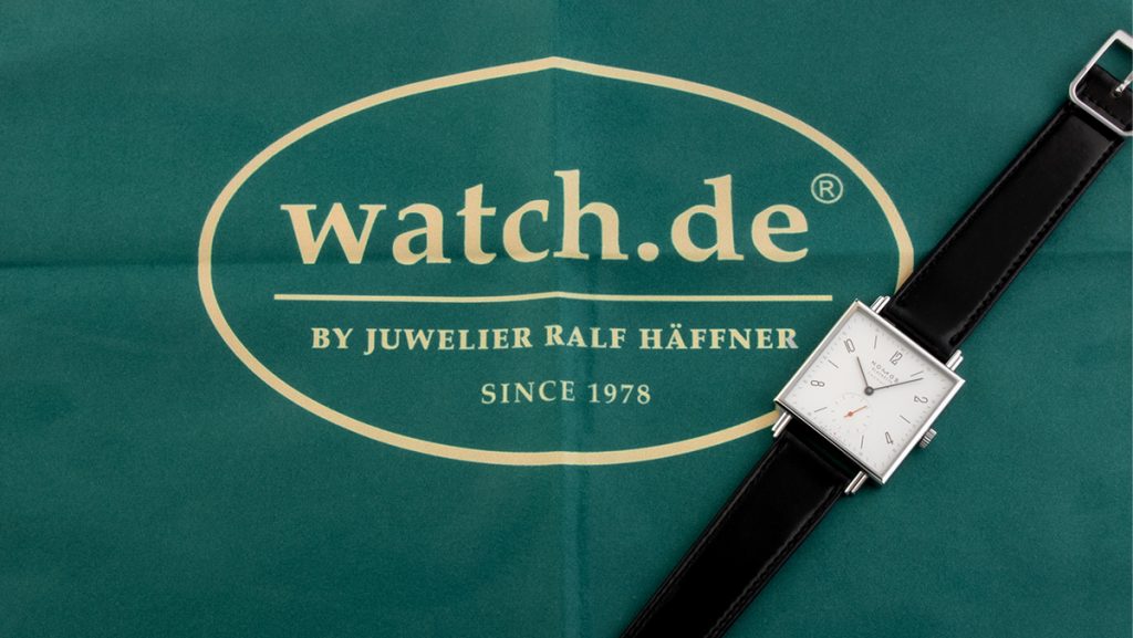 Eckige Uhr von Nomos mit Lederband auf Poliertuch von watch.de