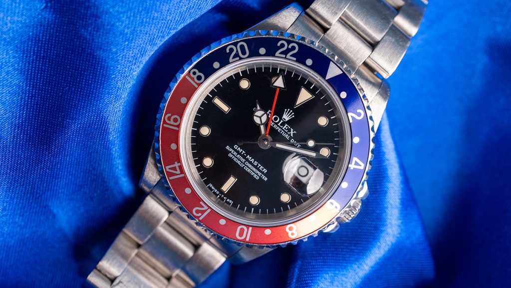 Beliebte Rolex GMT-Master Pepsi mit blau-roter Lünette auf blauem Tuch